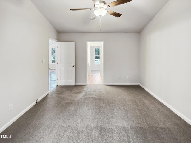 carpeted spare room featuring ceiling fan