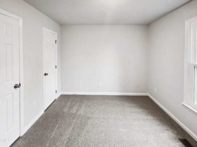 carpeted spare room featuring a textured ceiling