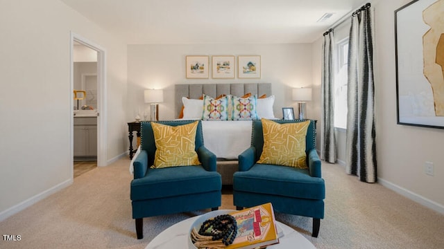 bedroom with light colored carpet and ensuite bath