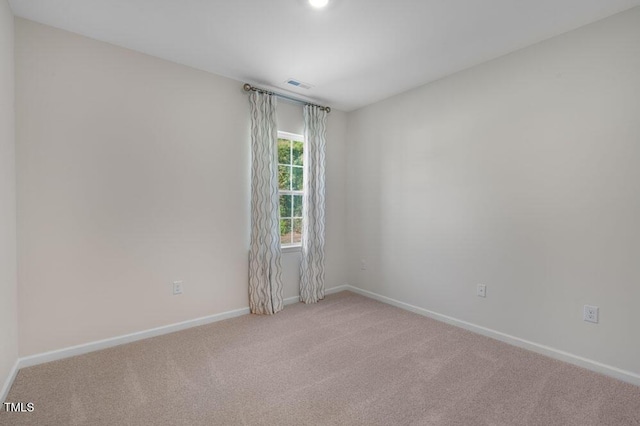 spare room featuring light colored carpet