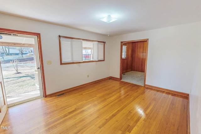 spare room featuring visible vents, plenty of natural light, and light wood finished floors