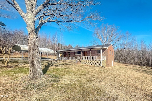 view of front of home with a front yard, a carport, and a porch