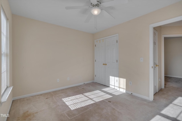 unfurnished bedroom featuring ceiling fan, light colored carpet, and a closet