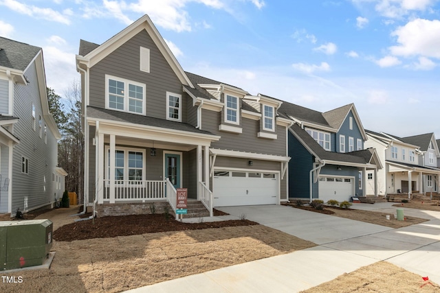 view of property featuring a porch, an attached garage, a residential view, and concrete driveway