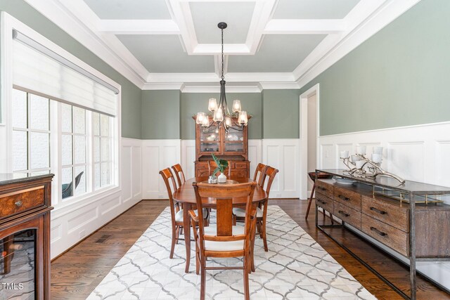 dining room with an inviting chandelier, crown molding, a decorative wall, dark wood-type flooring, and coffered ceiling