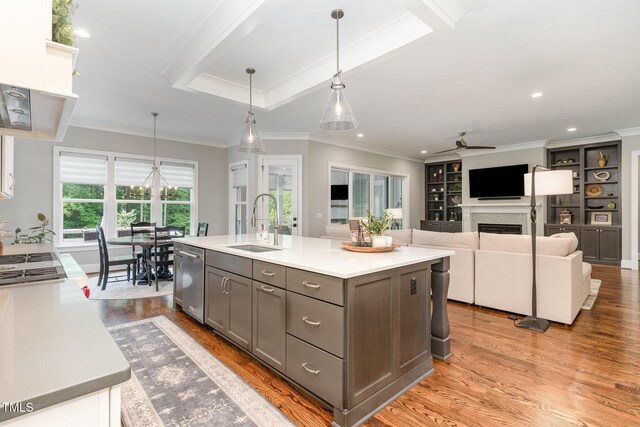 kitchen featuring a ceiling fan, light wood-style floors, gray cabinets, a sink, and dishwasher