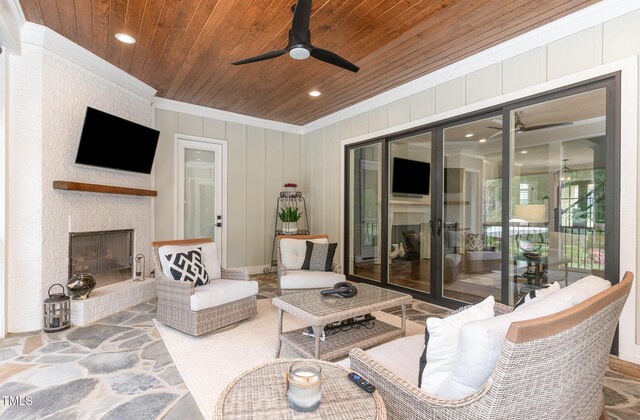 living room with crown molding, wooden ceiling, ceiling fan, and a large fireplace