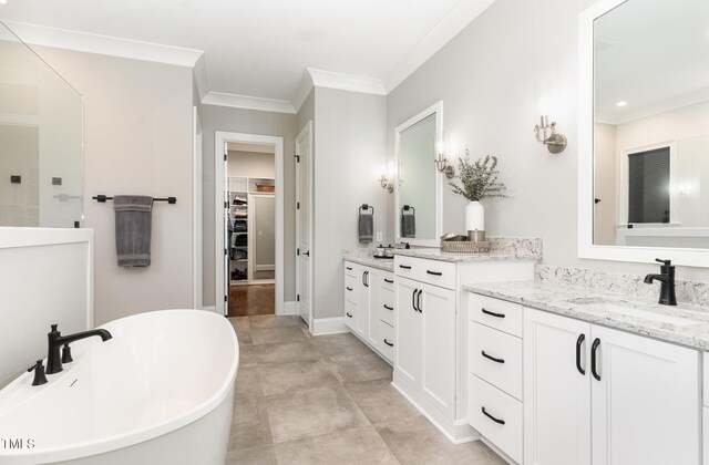 bathroom with a freestanding tub, a walk in shower, vanity, a spacious closet, and ornamental molding