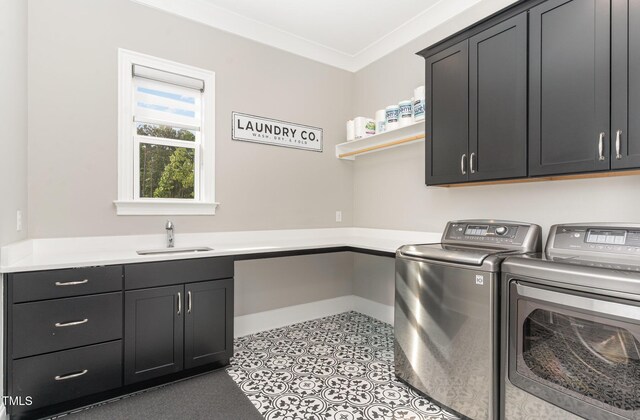washroom featuring a sink, crown molding, cabinet space, and washer and dryer