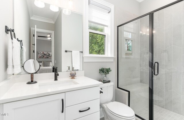 ensuite bathroom featuring a stall shower, vanity, ornamental molding, toilet, and ensuite bathroom