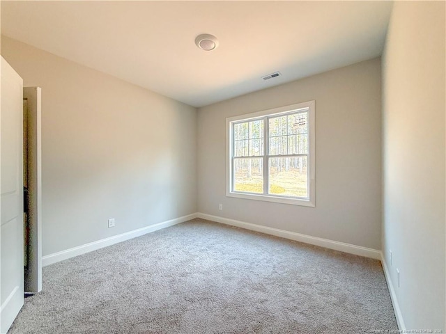 unfurnished room featuring baseboards, visible vents, and carpet flooring