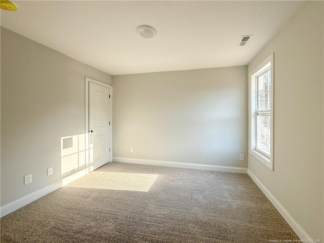 carpeted spare room with baseboards and visible vents