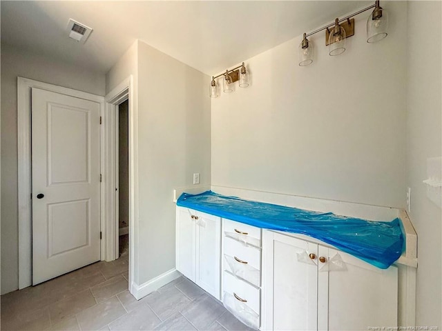 bathroom featuring baseboards and visible vents