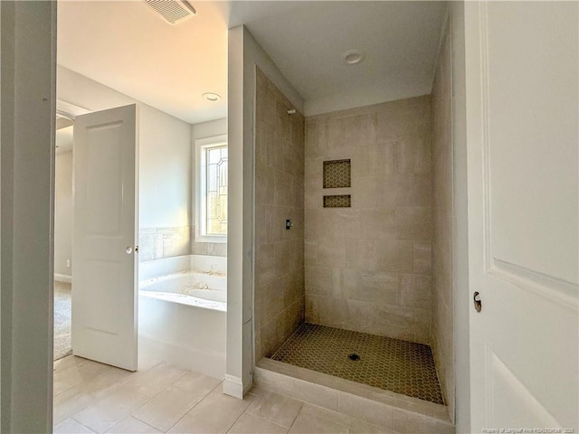 bathroom featuring tile patterned floors, visible vents, tiled shower, and a bath