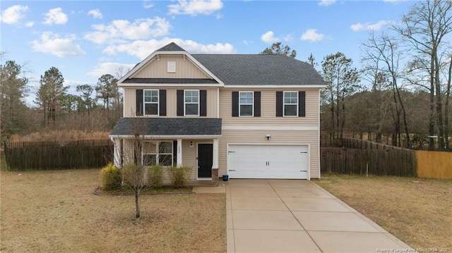 view of front of home featuring a front yard, concrete driveway, fence, and an attached garage