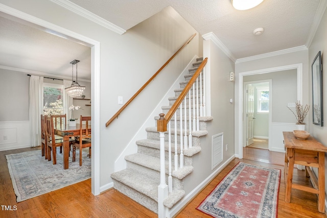 stairs featuring plenty of natural light, wood finished floors, and visible vents