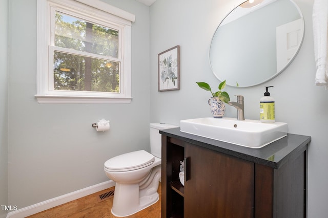 bathroom featuring baseboards, toilet, and vanity