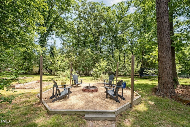 view of yard with a trampoline and a fire pit