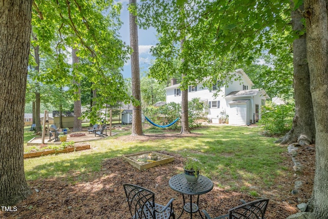 view of yard with a garden, a fire pit, and a patio area