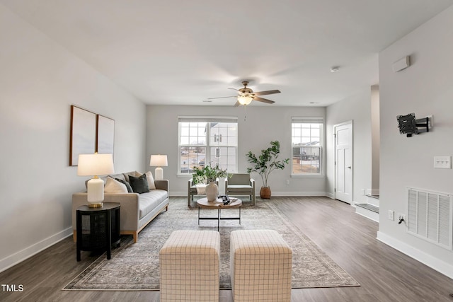 living room featuring dark wood-type flooring and ceiling fan