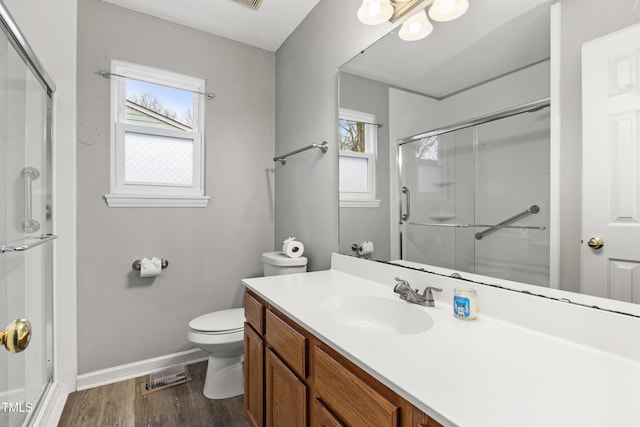 bathroom with walk in shower, wood-type flooring, toilet, and a wealth of natural light