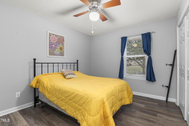 bedroom with ceiling fan, a closet, dark hardwood / wood-style floors, and a textured ceiling