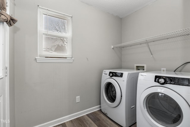 washroom featuring dark hardwood / wood-style flooring, washing machine and dryer, and a textured ceiling