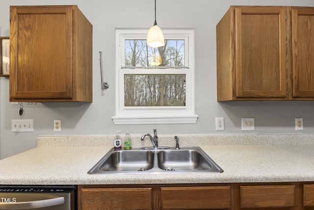 kitchen with stainless steel dishwasher, decorative light fixtures, and sink