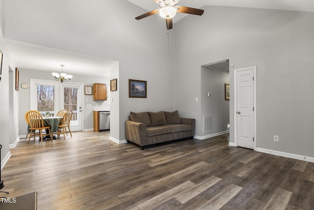 living room featuring ceiling fan with notable chandelier, dark wood-type flooring, and high vaulted ceiling