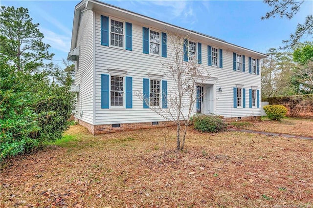 colonial-style house featuring a front yard