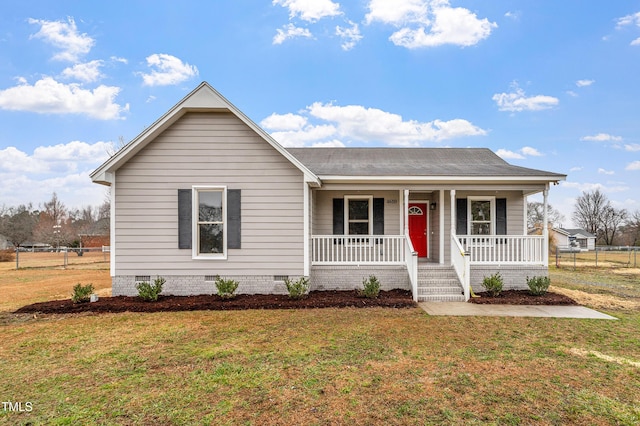 ranch-style home featuring covered porch and a front yard