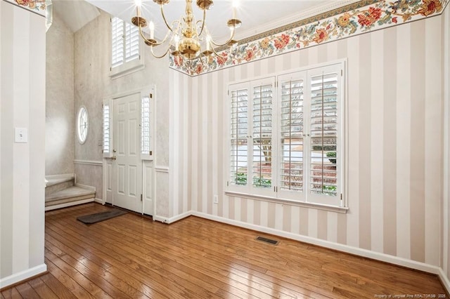 entryway featuring wood-type flooring, a healthy amount of sunlight, and a notable chandelier