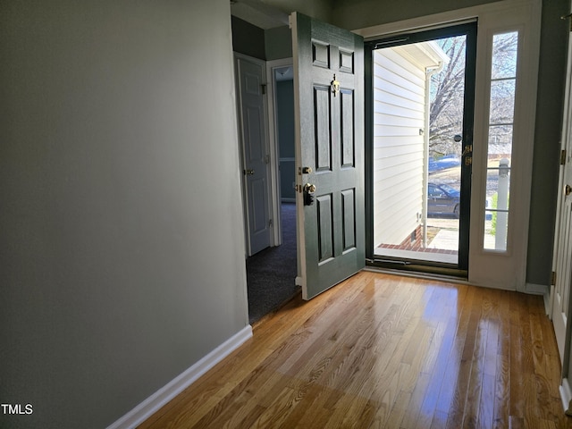 entryway with light wood-style flooring and baseboards