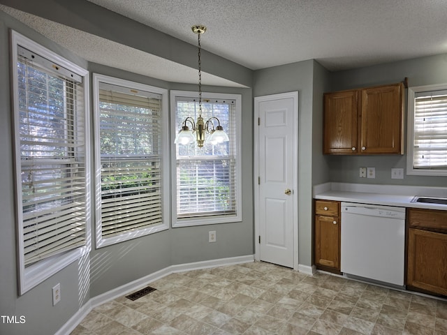 kitchen with brown cabinets, light countertops, dishwasher, and hanging light fixtures