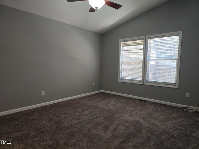 unfurnished room with a ceiling fan, lofted ceiling, baseboards, and dark colored carpet