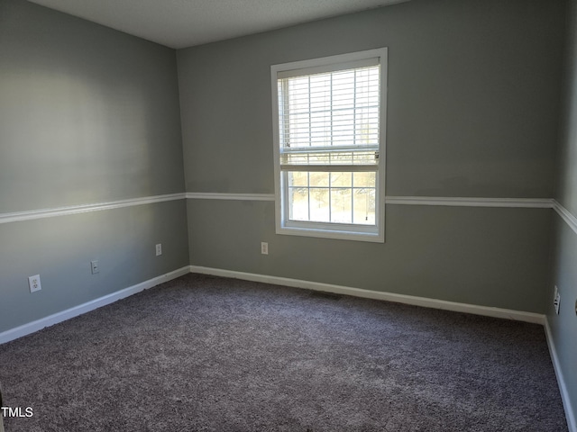 carpeted spare room with baseboards