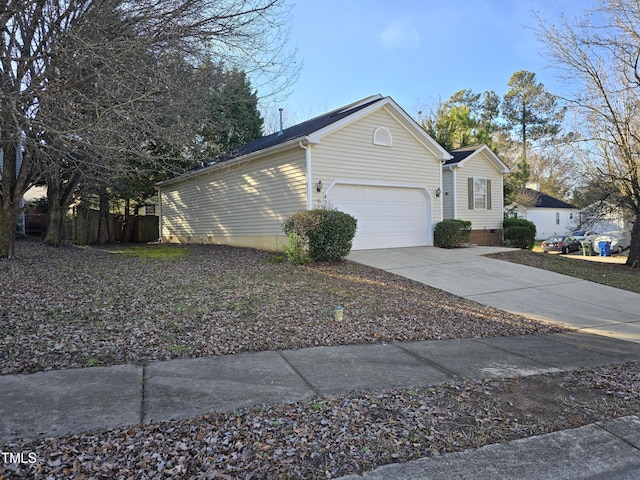 view of side of home featuring a garage, crawl space, and driveway