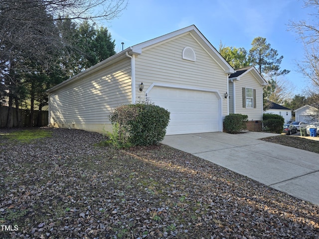 view of side of property with crawl space, an attached garage, and concrete driveway