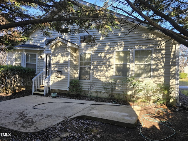 view of home's exterior with entry steps and a patio