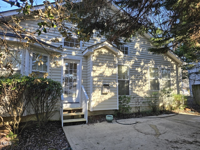 back of property featuring entry steps and a patio