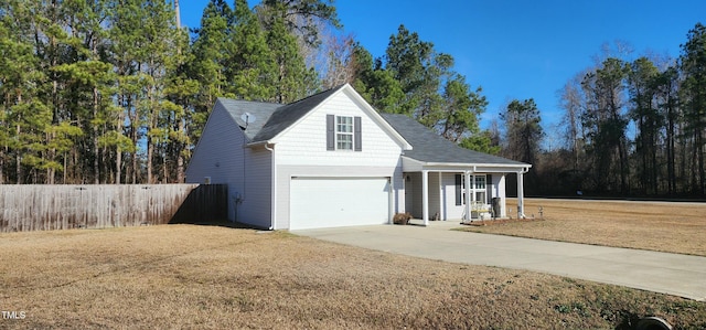 view of property featuring a porch, a garage, and a front lawn