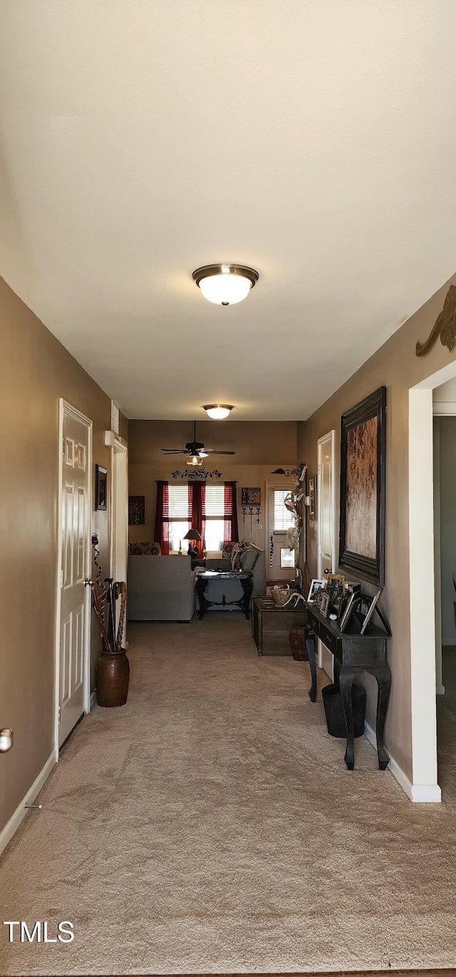 unfurnished living room with carpet and ceiling fan