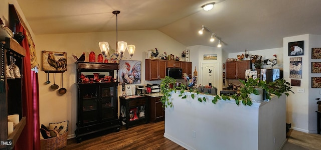 kitchen with pendant lighting, lofted ceiling, stainless steel fridge, dark hardwood / wood-style flooring, and an inviting chandelier