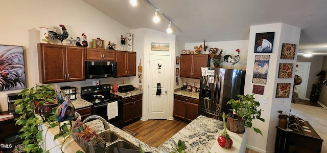 kitchen featuring stainless steel refrigerator with ice dispenser, dark wood-type flooring, sink, black range with electric stovetop, and light stone countertops