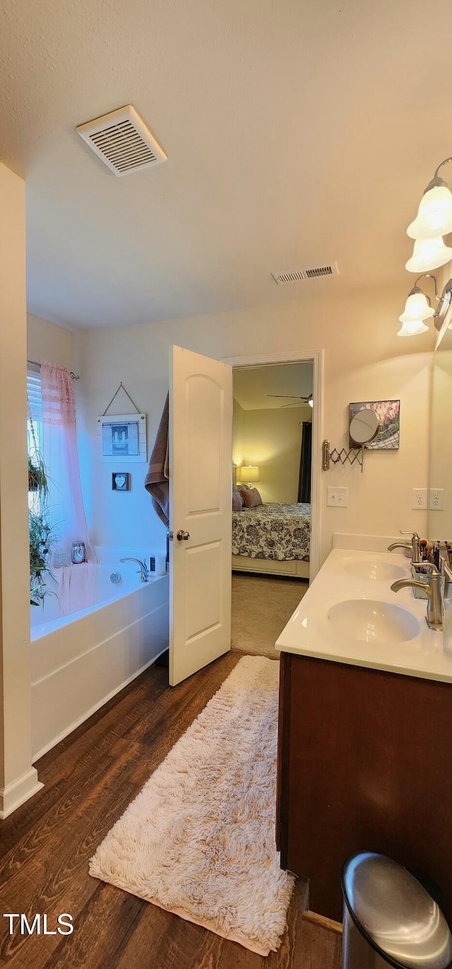 bathroom featuring hardwood / wood-style flooring, vanity, and a bathtub