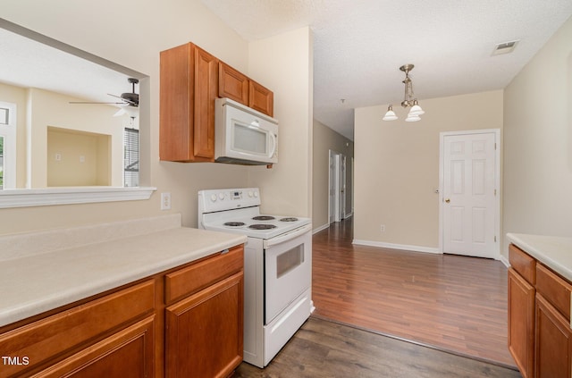 kitchen featuring white appliances, dark hardwood / wood-style floors, a textured ceiling, ceiling fan with notable chandelier, and decorative light fixtures