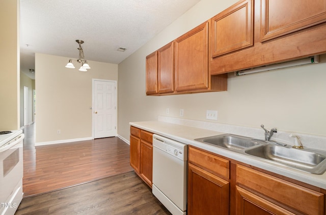 kitchen with decorative light fixtures, sink, white appliances, dark wood-type flooring, and a textured ceiling