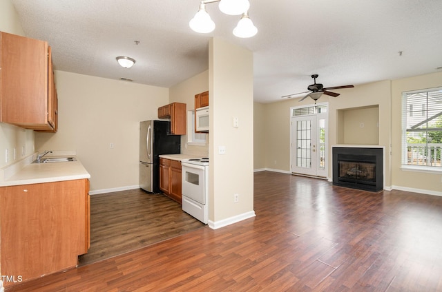 kitchen with pendant lighting, sink, dark wood-type flooring, and white appliances