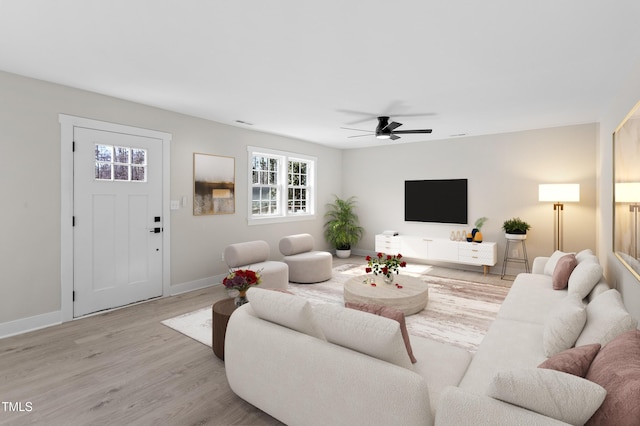 living room featuring light hardwood / wood-style flooring and ceiling fan