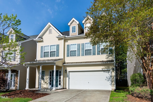 104 Mainline Station Dr, Durham, NC 27560 - view of front of house with a standing seam roof, driveway, an attached garage, and a metal roof